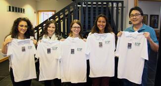 Several students and Dr. Aaron Ebata holding Energy Conservation Incentive Program shirts
