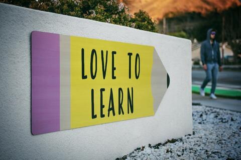 Drawing of a pencil on a white wall that reads "Love to Learn"